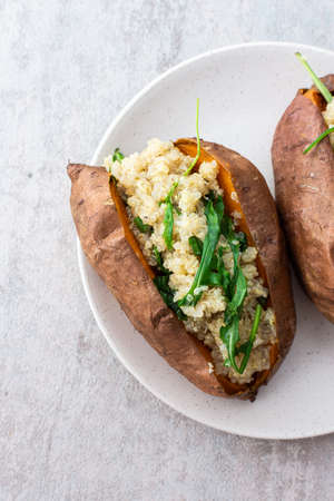 Baked in skin sweet potato with quinoa and lettuce close-up on a plate, vegetarian foodの写真素材