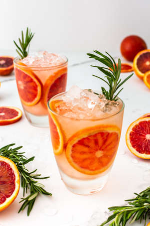 Fruity refreshing drink with blood oranges and ice and rosemary, delicious sweet juiceの写真素材