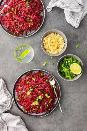 Vegetarian salad with couscous and grated beets, parsley and dill and green onions, light healthy tasty saladの写真素材