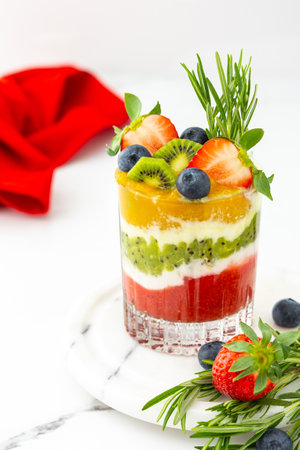 Strawberry, kiwi and mango smoothies with natural yogurt in glasses, decorated with fruits and berries and rosemaryの写真素材