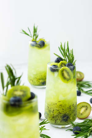 Refreshing drink with kiwi smoothie, summer sweet fruit juice with blueberries and rosemaryの写真素材