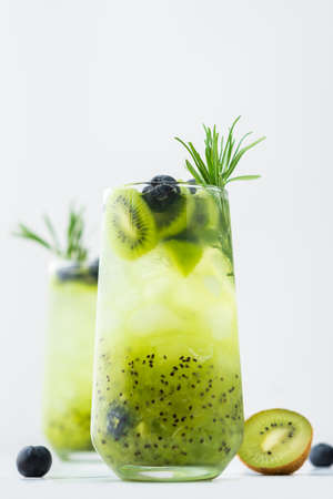 Refreshing drink with kiwi smoothie, summer sweet fruit juice with blueberries and rosemaryの写真素材