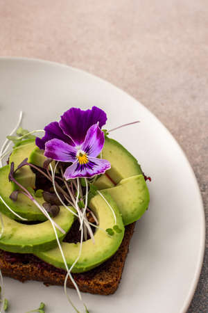 Sandwiches with boiled beetroot and avocado with microgreens, delicious healthy breakfastの写真素材