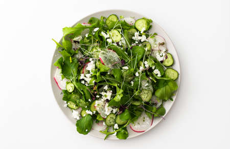 Delicious light salad with cucumbers and arugula, feta and microgreens, radishes and dillの写真素材