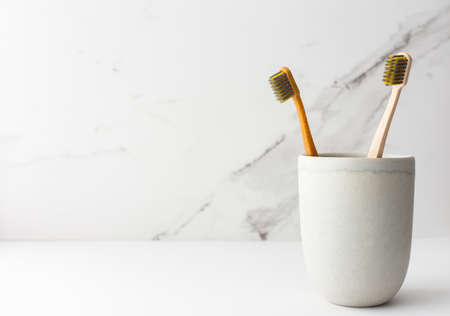 Wooden toothbrushes with natural bristles in a ceramic glass, natural oral hygiene productsの写真素材