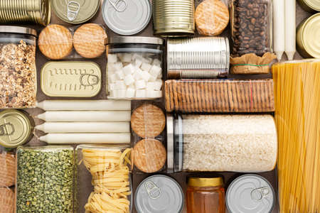 Top view of the background of the necessary products for the period of the pandemic or famine or quarantine and isolation, food stock, the concept of stay at home, donated products, grocery deliveryの写真素材