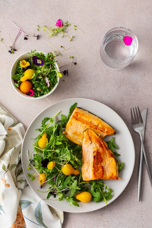 Delicious lunch with salad and fried char, healthy red fish and microgreens with cherry tomatoes, top view, copy spaceの写真素材