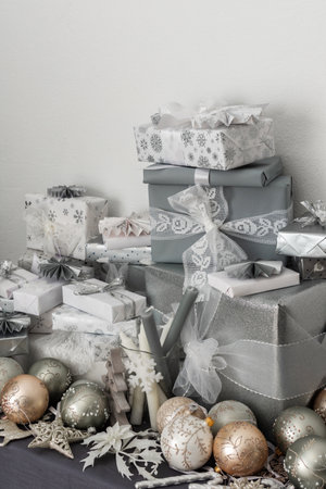 Preparations for the holiday, for dressing the Christmas tree, gifts and Christmas toys and decorations on the table near the fir treeの写真素材