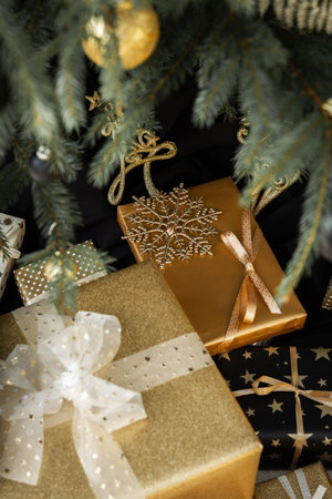 Black and gold gift boxes with bows under the Christmas tree, Merry Christmas and Happy New Yearの写真素材