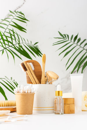 Wooden toothbrushes with natural bristles in a ceramic glass, face and skin care products, bottles with a pipette and a jar of cream, bath accessories, spa and beauty conceptの写真素材
