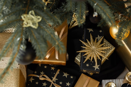 Black and gold gift boxes with bows under the Christmas tree, Merry Christmas and Happy New Yearの写真素材