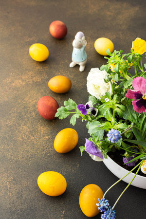 Top view of a vase with beautiful blooming flowers and Easter eggs, cute bunnies, copy spaceの写真素材