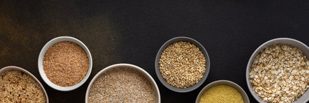 Various grain cereals in bowls banner, top view on a brown background with bowls of cerealsの写真素材