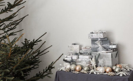 Preparations for the holiday, for dressing the Christmas tree, gifts and Christmas toys and decorations on the table near the fir treeの写真素材