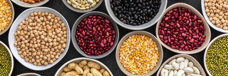 Banner of different types of legumes in bowls, green with yellow peas and mung beans, chickpeas and peanuts, colored beans and lentils, top viewの写真素材