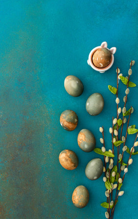 Cosmic Easter eggs with willow branches and cute bunnies on a turquoise background, top view, copy...