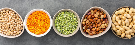 Banner of different types of legumes in bowls, green peas and chickpeas , beans and peanuts and lentils, top view, copy spaceの写真素材