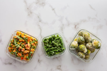 Frozen vegetables in containers , frozen cauliflower and asparagus beans, peas and corn, Brussels sprouts and carrots, mix of vegetables, top view, copy spaceの写真素材