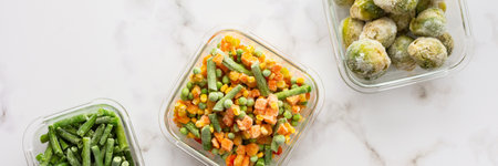 Frozen vegetables in containers banner , frozen cauliflower and asparagus beans, peas and corn, Brussels sprouts and carrots, mix of vegetables, top view, copy spaceの写真素材