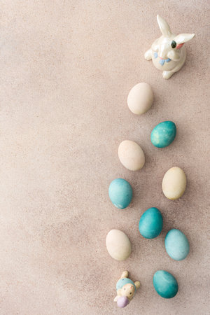 Colorful Easter eggs and cute bunnies on a pastel pink background, top view, copy spaceの写真素材