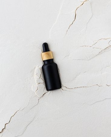 Moisturizing serum in a bottle with a pipette on an abstract background with cracks, hyaluronic serum or toner or lotion, face and body skin careの写真素材