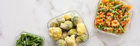 Frozen vegetables in containers banner, frozen cauliflower and asparagus beans, peas and corn, Brussels sprouts and carrots, mix of vegetables, top view, copy spaceの写真素材