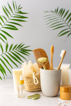 Wooden toothbrushes with natural bristles in a ceramic glass, face and skin care products, bottles with a pipette and a jar of cream, bath accessories, spa and beauty conceptの写真素材