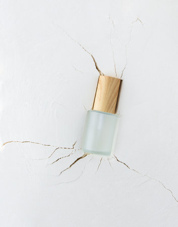 Moisturizing serum in a bottle with a pipette on an abstract background with cracks, hyaluronic serum or toner or lotion, face and body skin careの写真素材