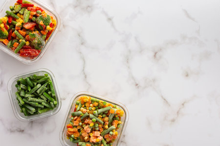 Frozen vegetables in containers , frozen cauliflower and asparagus beans, peas and corn, Brussels sprouts and carrots, mix of vegetables, top view, copy spaceの写真素材