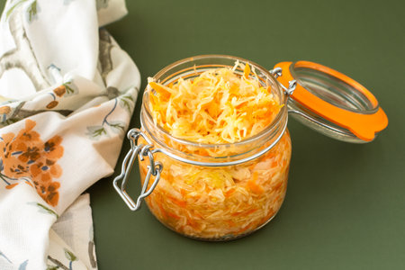 Fresh fermented vegetables, fermented cabbage with carrots in a glass jar on an olive background, healthy natural probiotics, healthy eating, sauerkrautの写真素材