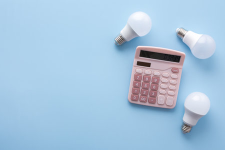 Save energy, accounting and saving money, energy saving light bulbs and notebook on a blue background, money spending planning, rising electricity costs, energy crisis in Europeの写真素材