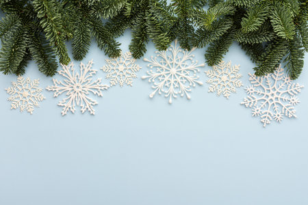 Fir branches and white snowflakes on a blue background , Merry Christmas and Happy New Year concept, top view, copy spaceの写真素材