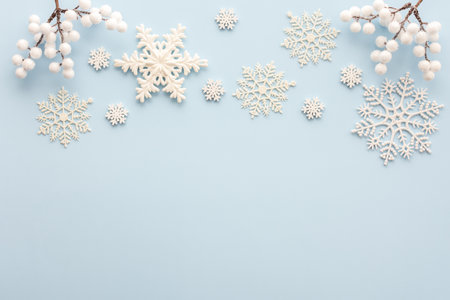 White snowflakes and rowan branches on a blue background, Christmas background, Merry Christmas and Happy New Year concept, top view, copy spaceの写真素材