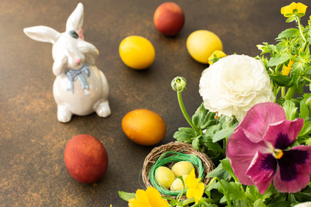 Top view of a vase with beautiful blooming flowers and Easter eggs, cute bunnies, copy spaceの写真素材