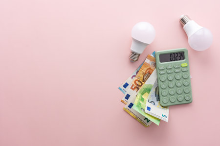 Save energy, accounting and saving money, energy saving light bulbs and notebook on a pink background, money spending planning, rising electricity costs, energy crisis in Europeの写真素材