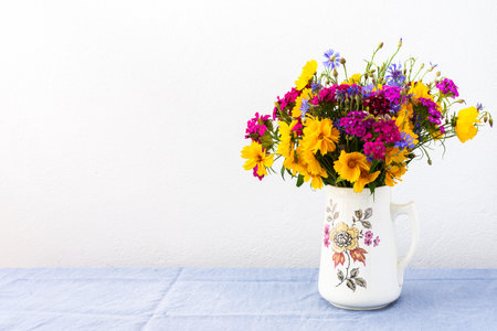 Beautiful summer bouquet of carnations, cornflowers and yellow chamomiles, part of home interiorの写真素材
