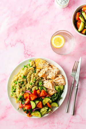 Healthy lunches, quinoa with green peas, with baked red fish salmon and fresh salad of tomato, cucumber and greens, top viewの写真素材