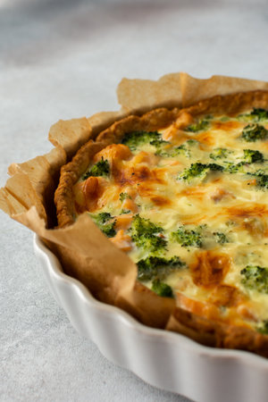 Homemade pie with red fish and broccoli, quiche with salmon and char, cheese and creamの写真素材