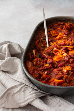 Healthy breakfasts and lunches, stewed red beans with carrots, onions and tomatoes, top view of an oval ceramic roaster with stewed legumesの写真素材