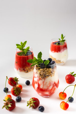 Healthy delicious breakfasts, glasses with muesli and yogurt, blueberries and strawberry smoothies, healthy breakfasts with seasonal berriesの写真素材