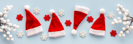 Santa Claus hats and snowflakes and rowan branches on a blue background, Christmas background, Merry...