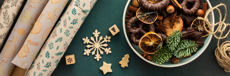 Preparing for the holiday, wrapping gifts under the Christmas tree in craft paper, Merry Christmas and New Year banner, plate with cookies and dry tangerine slicesの写真素材