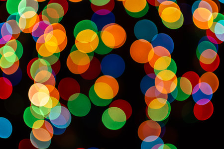 Christmas defocused lights, blurred colorful lights on a dark background, festive backgroundの写真素材