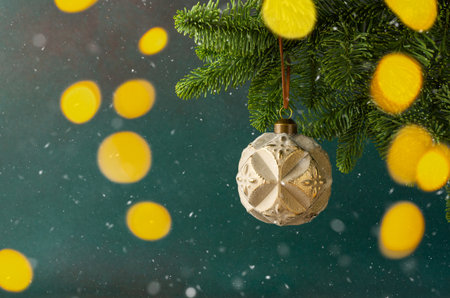 Christmas ball hanging on a fir branch on a green background, Christmas backgroundの写真素材