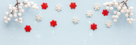 White and red snowflakes and rowan branches on a blue background, Christmas background, Merry Christmas and Happy New Year banner, top view, copy spaceの写真素材
