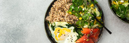 Delicious healthy breakfasts, green buckwheat with fried egg and spinach and red salmon fish, mix salad with fresh herbs and peppers and seeds, healthy balanced breakfast with fats, fiber and proteinの写真素材
