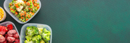Preparing food for the winter, freezing fresh vegetables in the summer in the refrigerator, various frozen vegetables in plastic dishes on a green background, bannerの写真素材