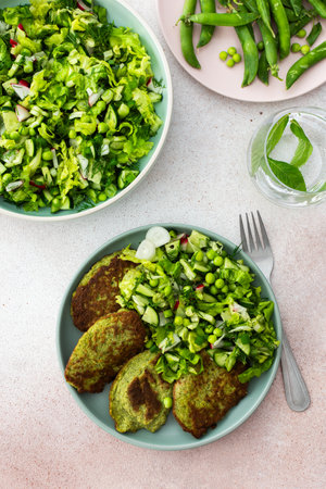Zucchini and broccoli pancakes served with a mixed salad of cucumbers, young peas, and radishes. This healthy vegetarian dish is both delicious and nutritiousの写真素材