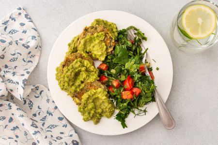Start your day with delicious zucchini pancakes and green pea pesto, accompanied by a vibrant salad of fresh vegetables and herbs, perfect for a healthy and balanced breakfastの写真素材