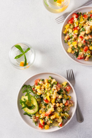 This healthy salad combines boiled millet, chickpeas, fresh vegetables, and avocado, all drizzled with olive oil for a nutritious and flavorful vegetarian mealの写真素材
